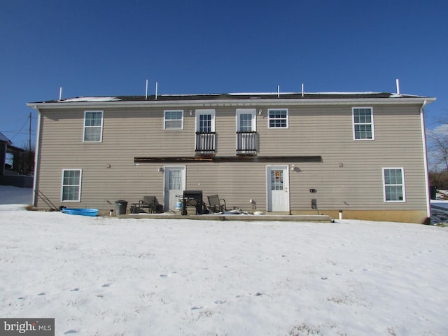 view of snow covered rear of property