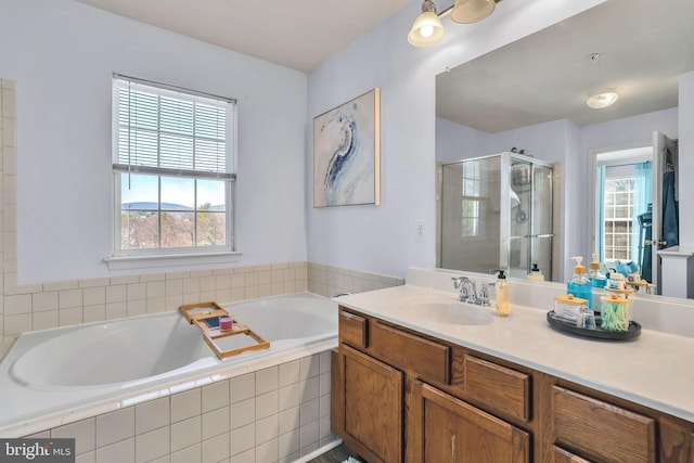 full bath featuring a wealth of natural light, a garden tub, a shower stall, and vanity