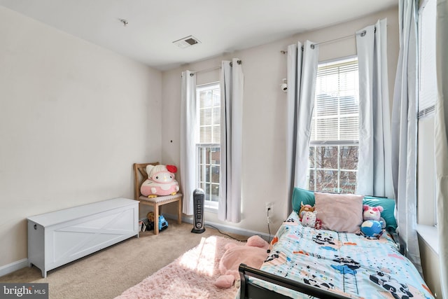 bedroom with carpet floors, baseboards, multiple windows, and visible vents