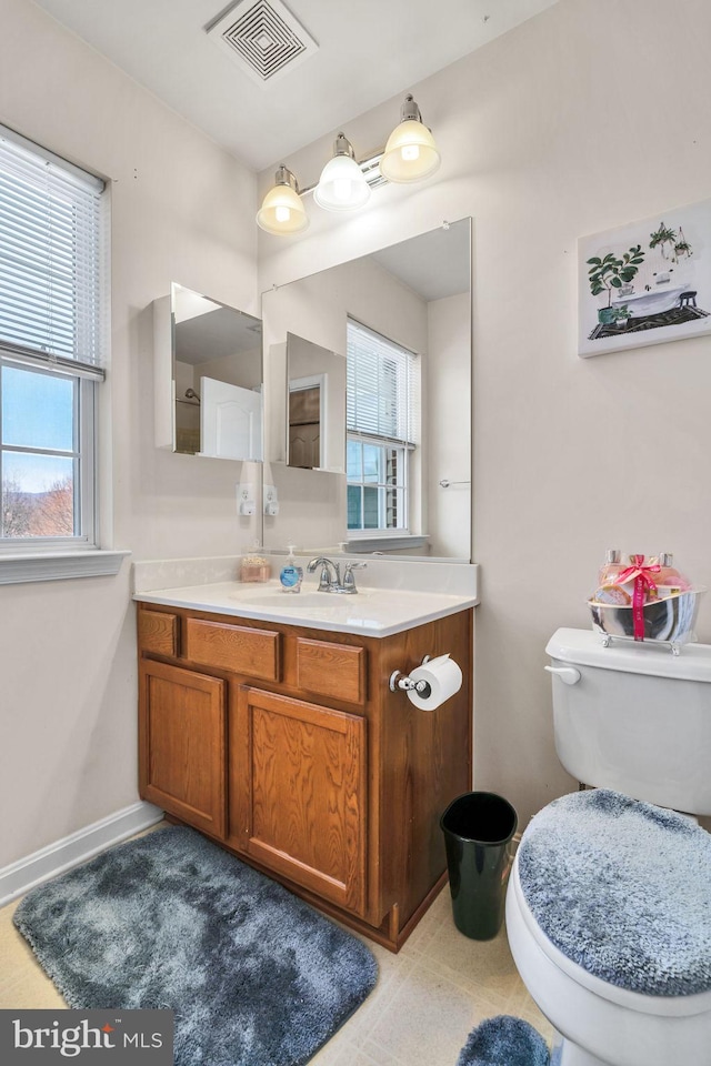 bathroom featuring toilet, baseboards, visible vents, and vanity