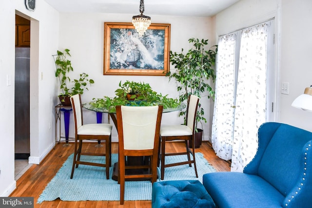 dining space with dark hardwood / wood-style flooring and a notable chandelier