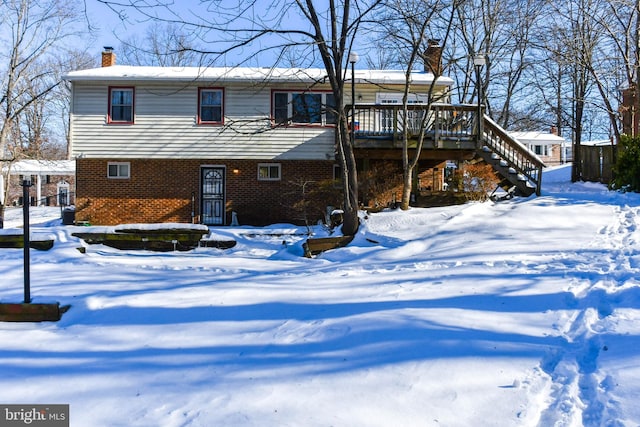 snow covered property with a deck