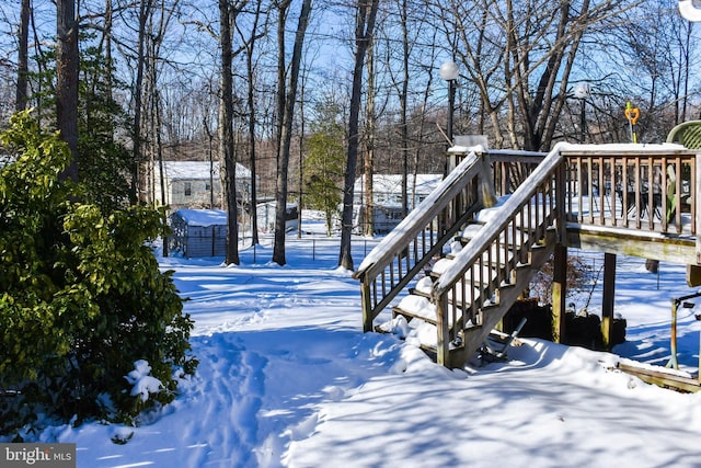 yard covered in snow featuring a deck