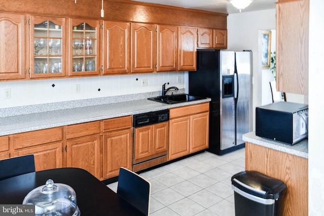 kitchen with paneled dishwasher, sink, stainless steel refrigerator with ice dispenser, tasteful backsplash, and light tile patterned flooring