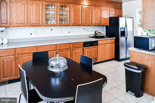 kitchen featuring sink, paneled dishwasher, backsplash, stainless steel fridge, and light tile patterned flooring