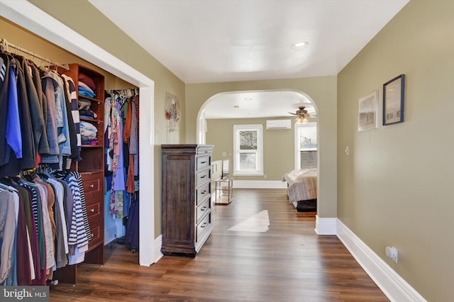 hallway featuring a wall mounted air conditioner and dark hardwood / wood-style floors