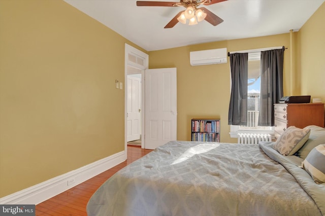 bedroom featuring ceiling fan, a wall mounted AC, radiator, and wood-type flooring