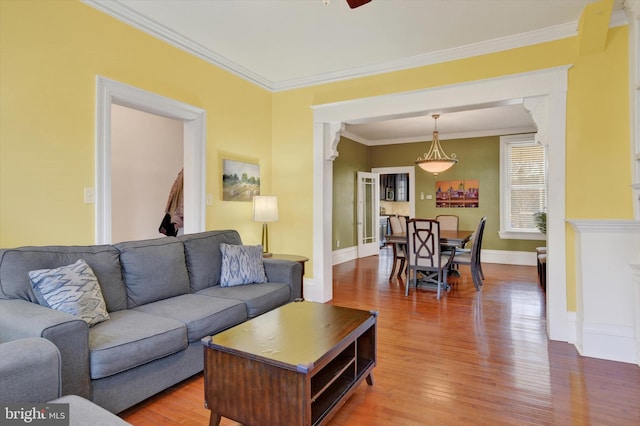 living room featuring ceiling fan, crown molding, and hardwood / wood-style flooring