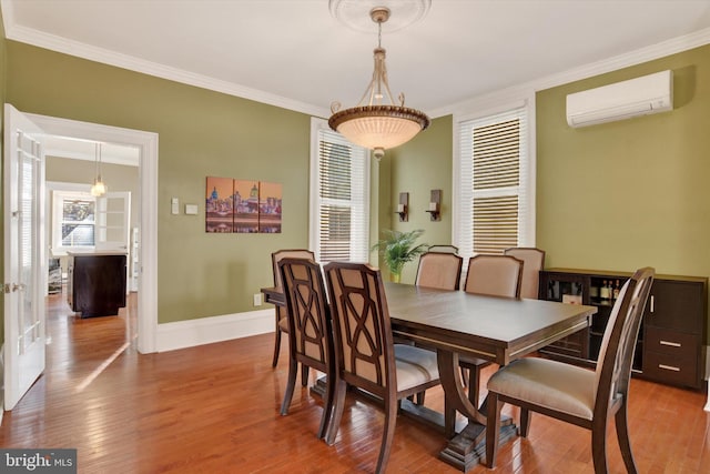 dining space with hardwood / wood-style floors, ornamental molding, and a wall mounted AC