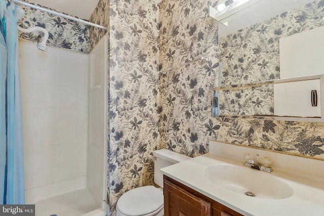 bathroom featuring toilet, vanity, and walk in shower