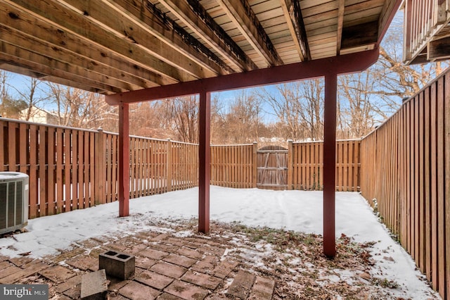 snow covered patio featuring central AC unit