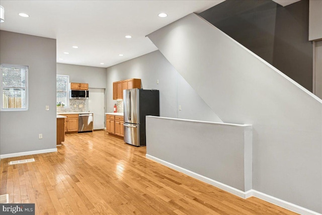 kitchen featuring stainless steel appliances, tasteful backsplash, and light hardwood / wood-style floors