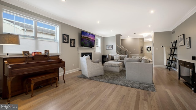 living room featuring light hardwood / wood-style flooring and crown molding