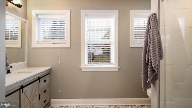 bathroom featuring a shower, vanity, and toilet