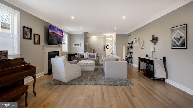 living room featuring light hardwood / wood-style flooring and ornamental molding