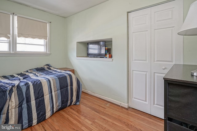 bedroom with a closet and light hardwood / wood-style flooring