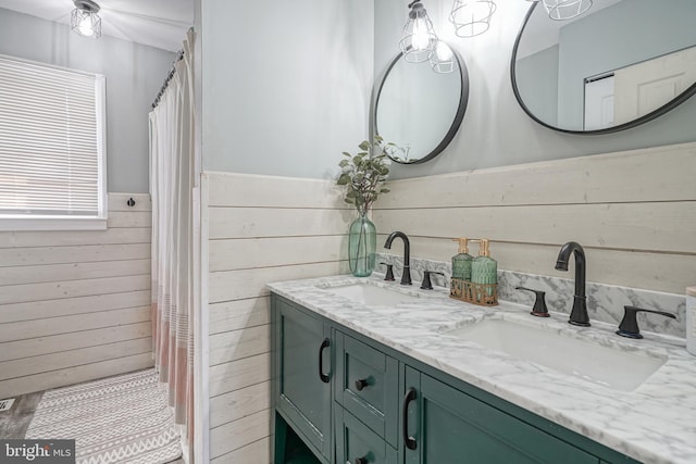 bathroom with vanity and wood walls