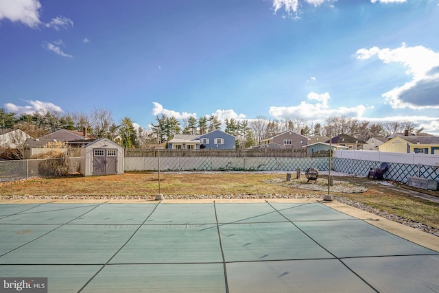 view of swimming pool featuring a yard and a storage shed