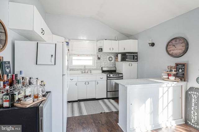 kitchen featuring vaulted ceiling, backsplash, sink, stainless steel appliances, and white cabinets