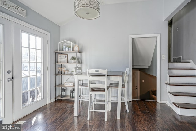 dining space featuring dark hardwood / wood-style floors, lofted ceiling, and french doors