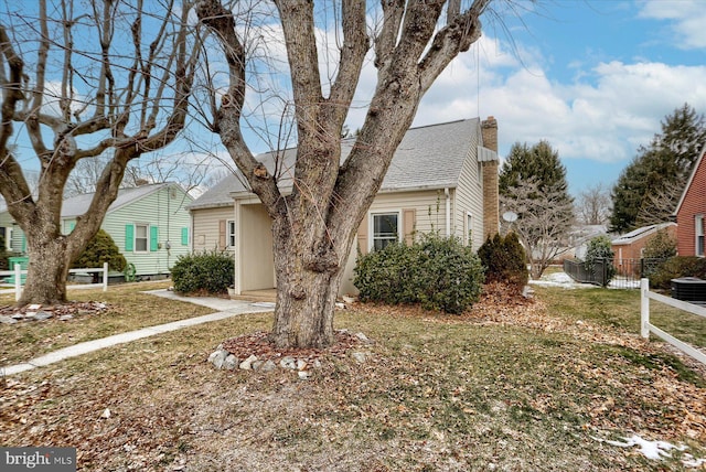 view of front of home with a front lawn and central AC