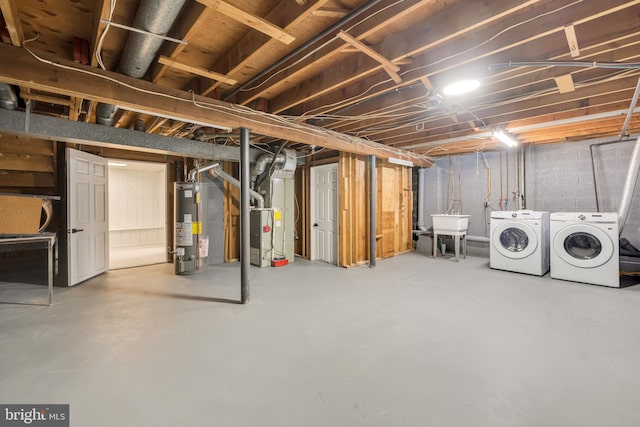 basement with sink, water heater, washing machine and clothes dryer, and heating unit