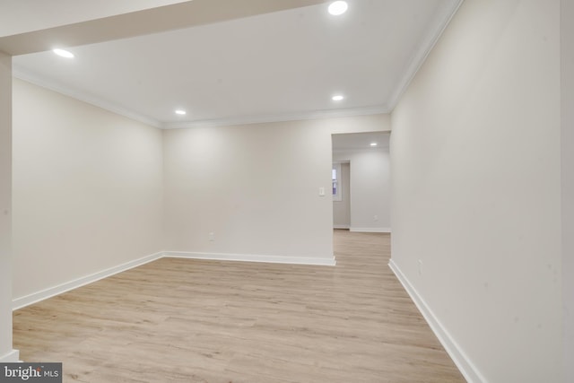 empty room with ornamental molding and light hardwood / wood-style floors