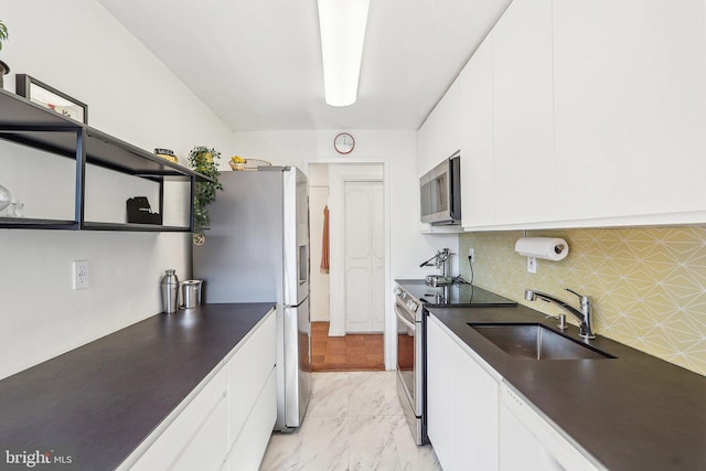 kitchen with white cabinets, appliances with stainless steel finishes, tasteful backsplash, and sink