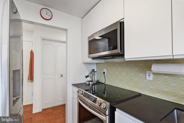 kitchen featuring stainless steel appliances, white cabinets, and decorative backsplash