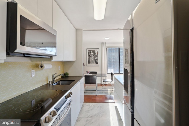 kitchen with sink, stainless steel appliances, white cabinetry, and tasteful backsplash