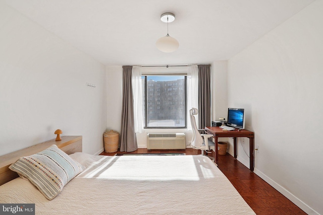 bedroom with a wall unit AC and dark hardwood / wood-style floors