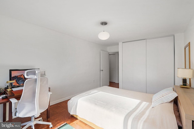 bedroom featuring a closet and dark parquet floors