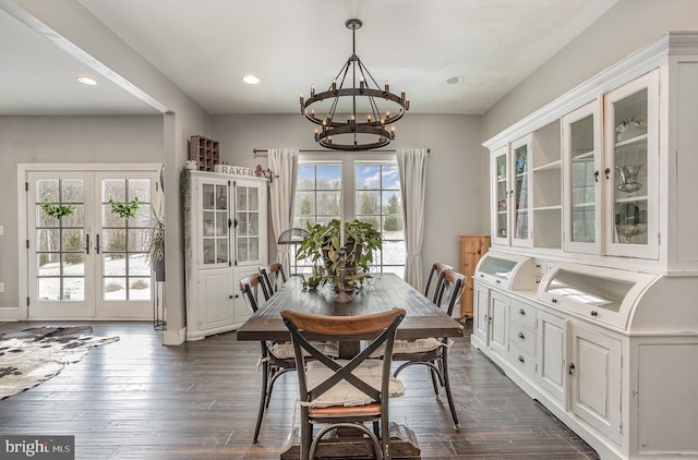 dining room featuring french doors, dark wood-type flooring, and a notable chandelier