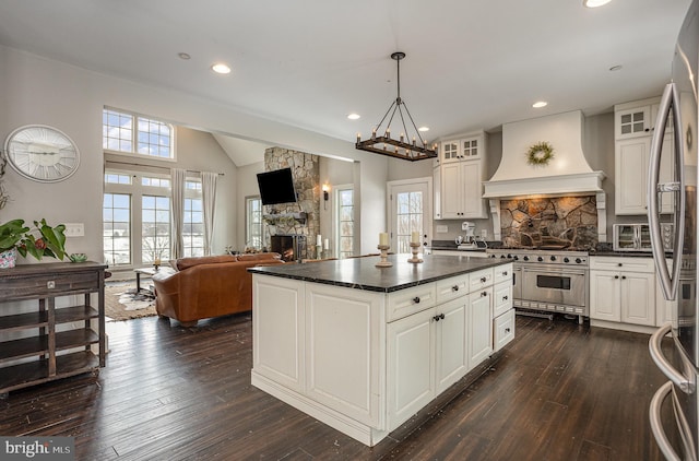 kitchen featuring white cabinetry, custom range hood, a fireplace, and appliances with stainless steel finishes