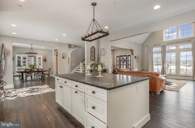 kitchen featuring white cabinets, dark hardwood / wood-style flooring, a center island, and decorative light fixtures