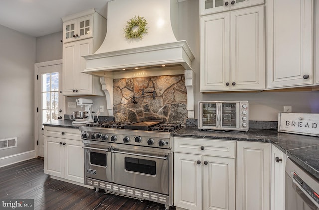 kitchen featuring white cabinetry, custom range hood, and stainless steel appliances