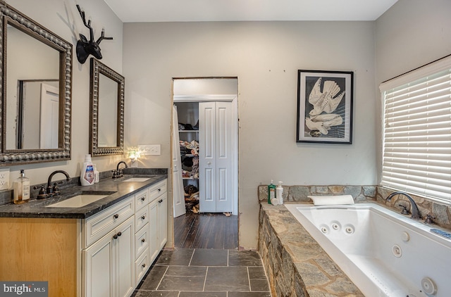 bathroom featuring vanity and tiled tub