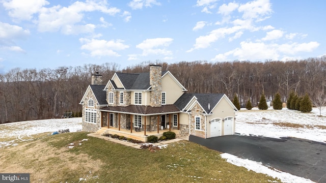 view of front of home featuring a lawn, a porch, and a garage