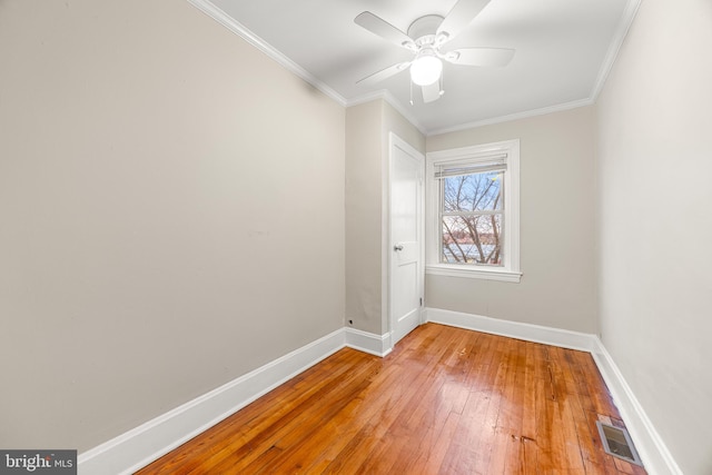 empty room with ceiling fan, wood-type flooring, and crown molding