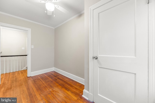 empty room with ceiling fan, ornamental molding, and hardwood / wood-style flooring