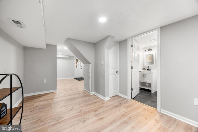 bonus room featuring light wood-type flooring and sink