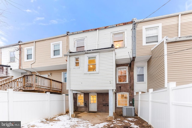 snow covered back of property with central AC unit