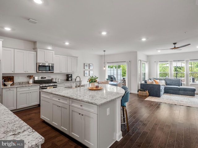 kitchen with white cabinets, decorative light fixtures, stainless steel appliances, and sink