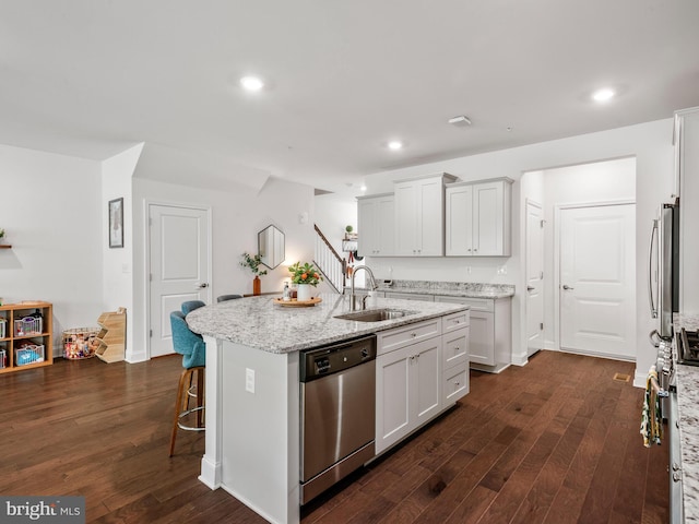 kitchen with white cabinetry, sink, dark wood-type flooring, a center island with sink, and appliances with stainless steel finishes