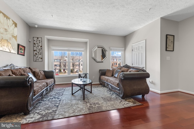 living room featuring wood finished floors, baseboards, and a textured ceiling