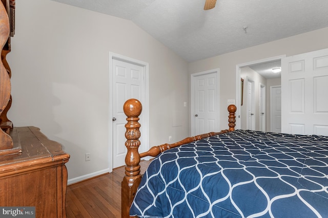 bedroom with baseboards, ceiling fan, vaulted ceiling, wood-type flooring, and a textured ceiling