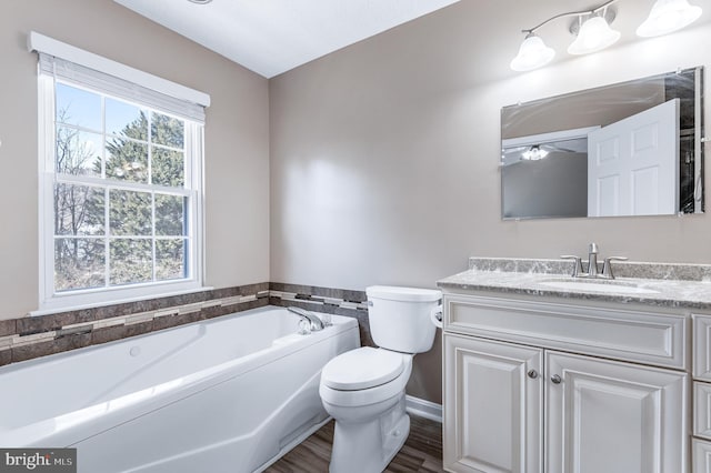 bathroom with a bath, toilet, vanity, and wood finished floors