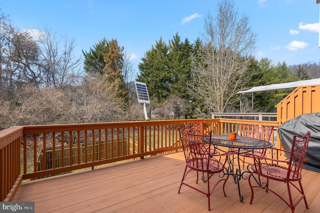 wooden deck featuring area for grilling and outdoor dining area