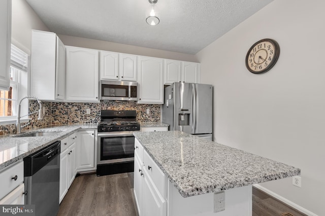 kitchen with a sink, stainless steel appliances, light stone countertops, and tasteful backsplash