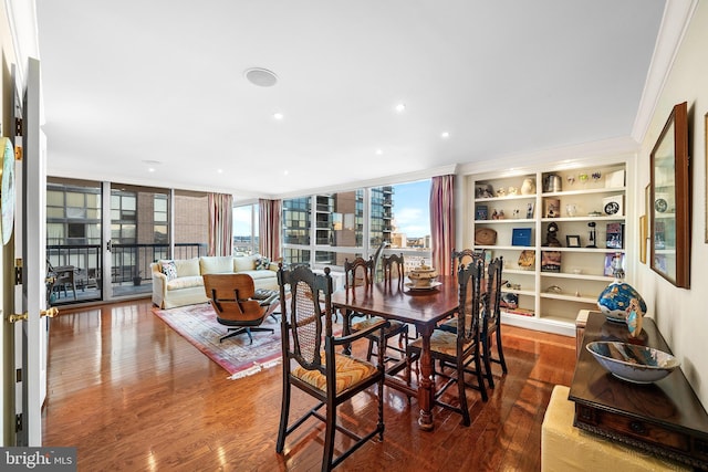 dining space featuring built in features, crown molding, expansive windows, and wood-type flooring